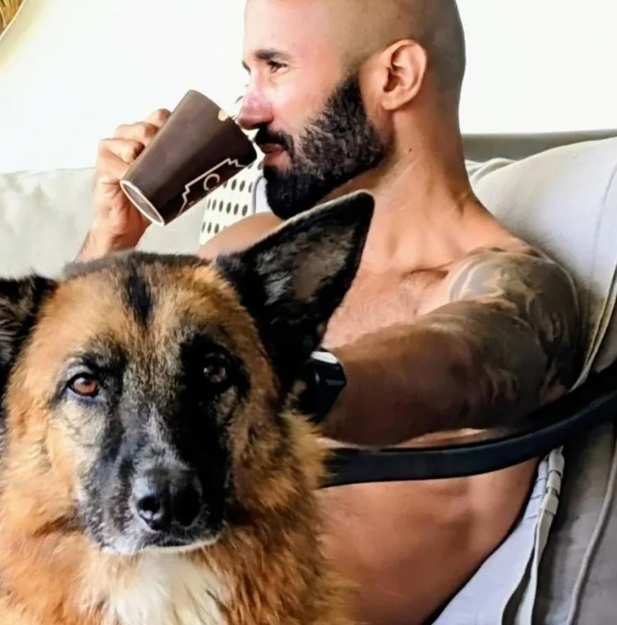 Charles V. on a couch with his ageing German Shepherd, holding a coffee, San Pancho 2021